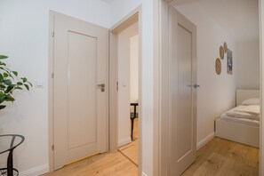 A room with a bed, a small table, and a potted plant. - ShortStayPoland Dąbrowszczaków B138 (Warsaw)