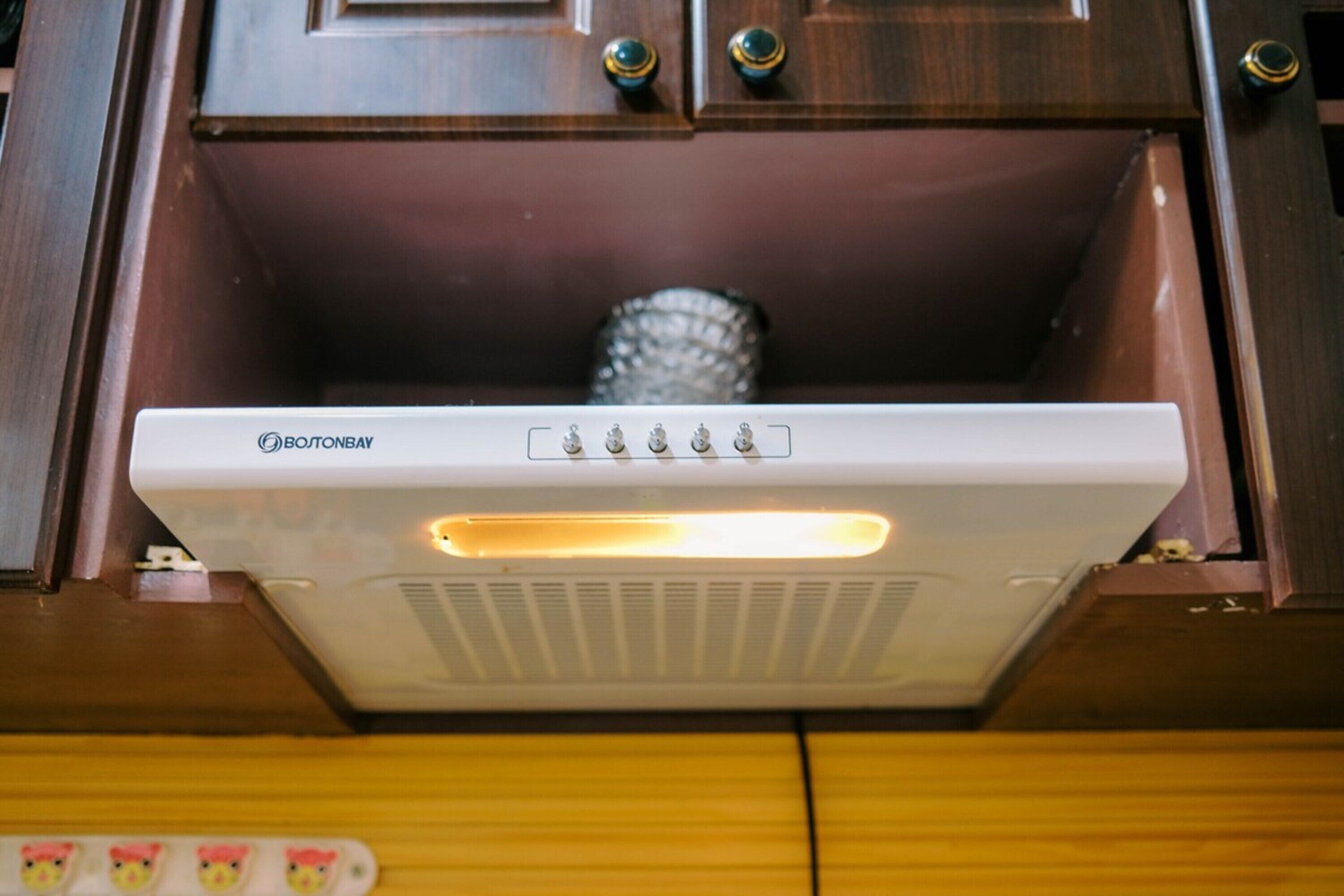Un radiateur portatif blanc, doté d’un panneau de commande, placé dans un meuble en bois.