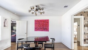 A dining area with a dark wooden table, black chairs, and a modern chandelier. - Welcome to Unit B (Houston)