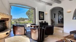 Amplia sala de estar con chimenea, asientos cómodos y vistas al exterior.