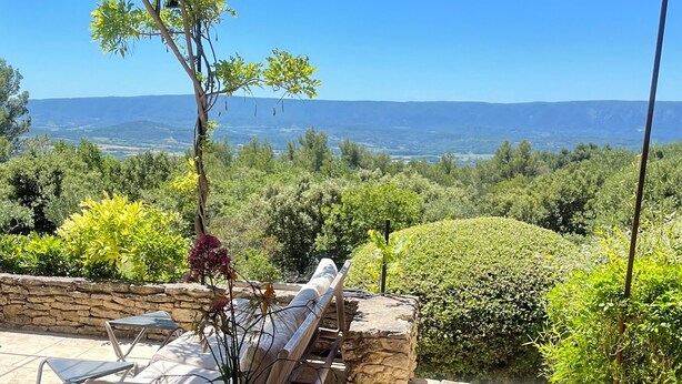 A terrace with stone walls, a hammock, and a view of a mountainous landscape. - Luxury villa in Gordes With Exceptional Views, Not Overlooked, Sleeps 16 (MURS)