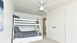 A bunk bed with storage drawers, a ceiling fan, and a wardrobe in a room with a carpeted floor. - Silverwater Serenity Shores Absolute Waterfront (Silverwater)