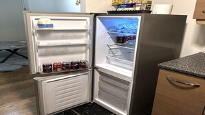 A compact refrigerator with multiple shelves, a freezer compartment, and a top freezer shelf.
