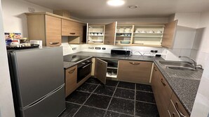 A compact kitchen with wooden cabinets, a built-in microwave, and a sink.