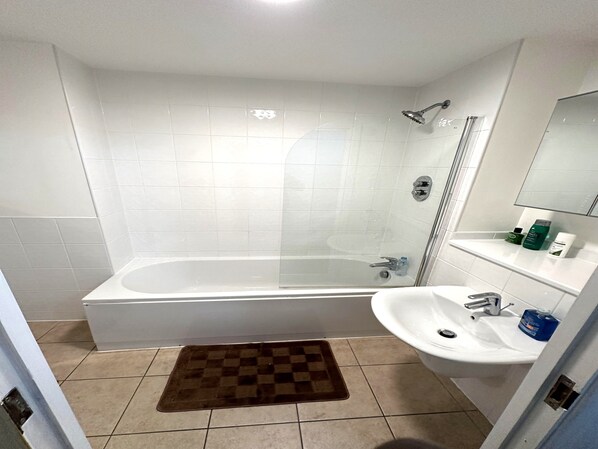 Une salle de bain moderne équipée d’une baignoire, d’une douche et d’un lavabo.