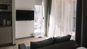 Une chambre d’hôtel équipée d’un lit, d’un téléviseur fixé au mur, d’un four à micro-ondes et offrant une vue sur l’extérieur par une porte.