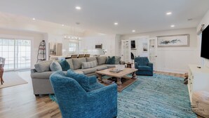 A spacious living area with a sofa, armchairs, and a coffee table. - 12 Heron Street- The Happy Heron (Hilton Head Island)