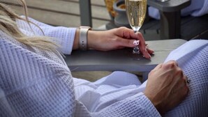 Two people seated at a table outdoors, each holding a glass of champagne. - Two Treehouses + Bridge | Double 20-Foot Slides | Smoky Mountain Views (Sevierville)