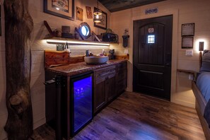A compact kitchen with a refrigerator, microwave, and a wooden cabinet. - Luxury Smoky Mountain Treehouse | 20-Foot Slide | Sleeps 6 | Near Dollywood (Sevierville)