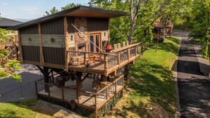 Eine Holzhütte mit einer Terrasse, Sitzmöglichkeiten im Freien und einem Grillbereich.