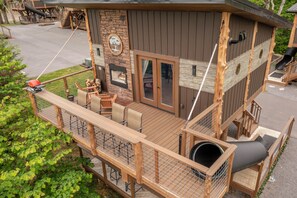 Une terrasse en bois, dotée de mobilier d’extérieur, d’une cheminée et offrant une vue sur les environs.
