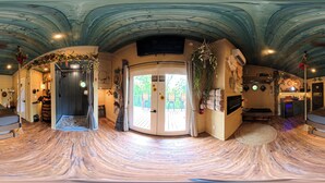 Ein geräumiger Raum mit gewölbter Decke, einem großen Fenster und einer gemütlichen Sitzecke.