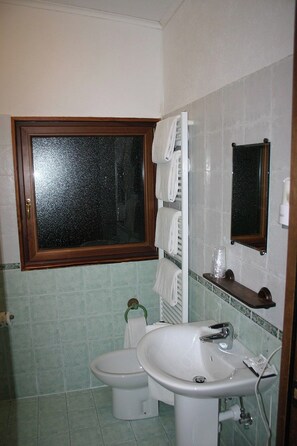 A bathroom with a toilet, sink, and a window. - Hotel La Pigna (Bardonecchia)