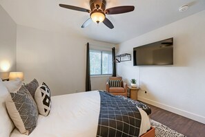 A bedroom with a bed, pillows, a ceiling fan, a mounted TV, a window with blinds, and a small side table with a plant. - 37c Hidden Creek Mountain Getaway! 3 Bedroom Condo by RedAwning (Park City)