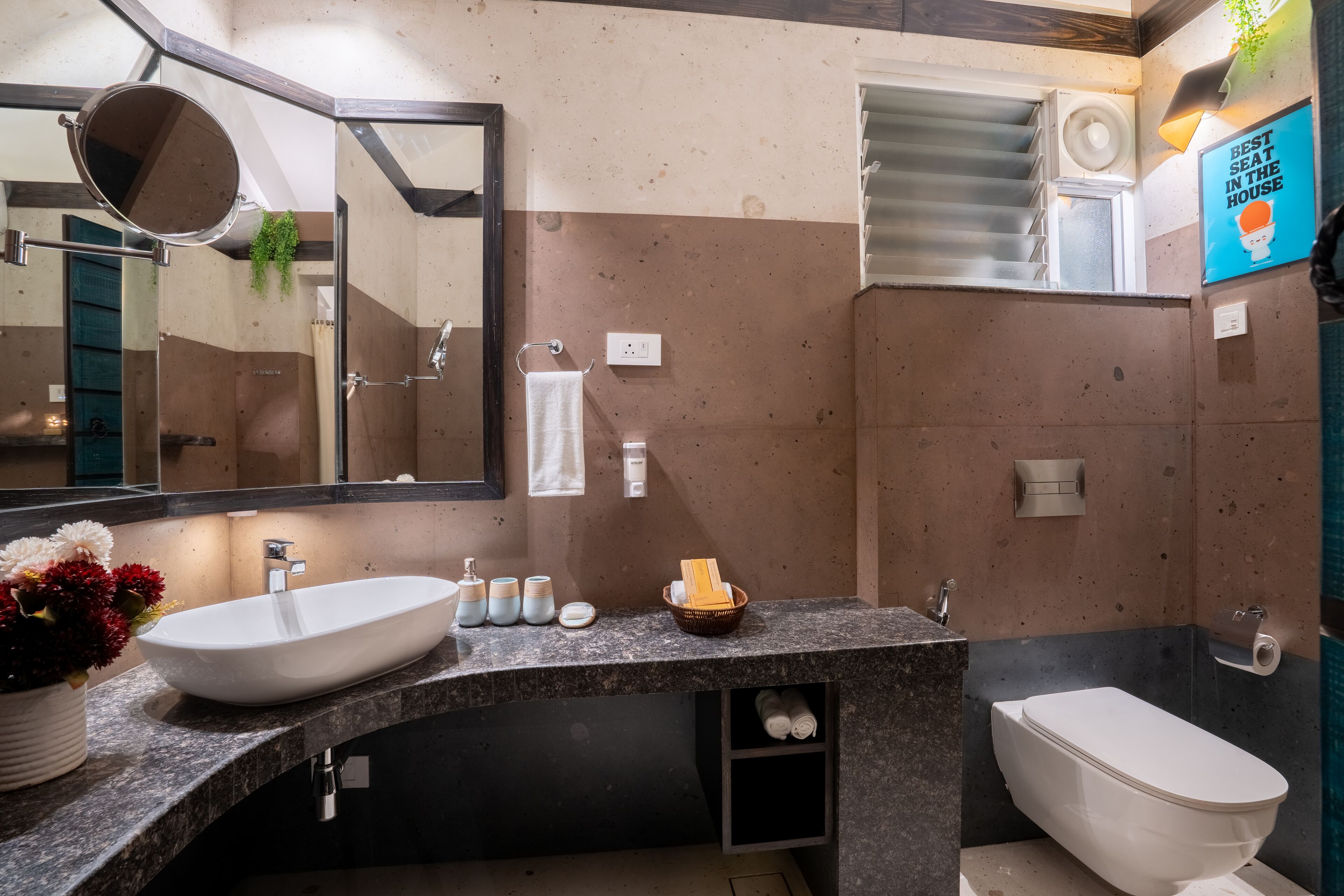 Un baño moderno con un lavabo grande, espejo e inodoro.