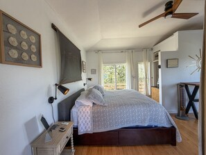 Een slaapkamer met een bed, nachtkastje, lamp en een wereldkaart aan de muur.