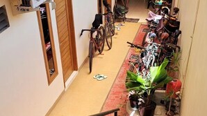 A staircase with a handrail leading to a landing where bicycles are parked and potted plants are arranged. - AJ Bike Guesthouse Syariah (Yogyakarta)