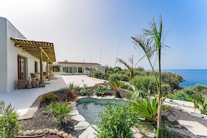 A modern house with a pool, outdoor seating, and a view of the sea. - Costa Mágica – Romantic Ocean Boutique Hotel &amp; Club (San Cristóbal de La Laguna)