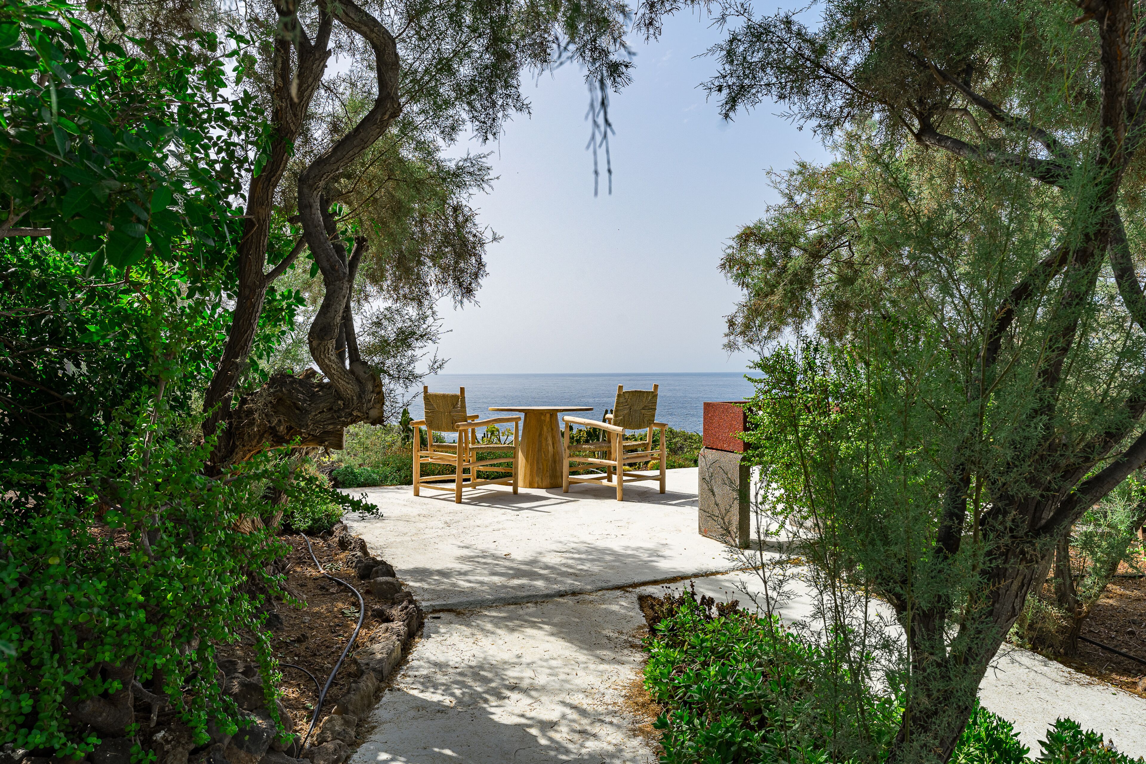 Une terrasse avec une table et des chaises donnant sur un plan d’eau.