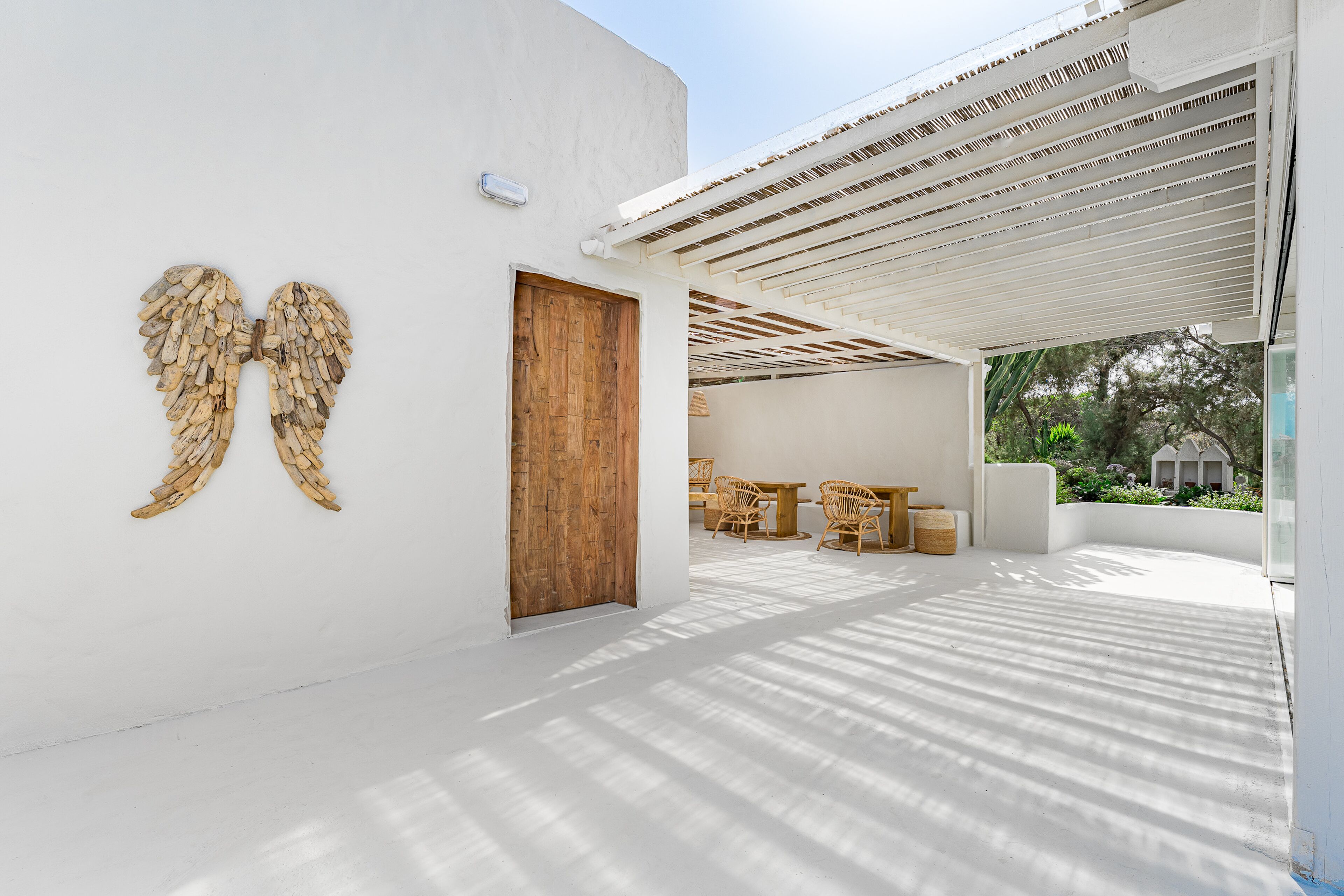 Ein modernes Interieur mit einer Holztür, weißen Wänden und einer Decke mit Holzlatten-Verkleidung.