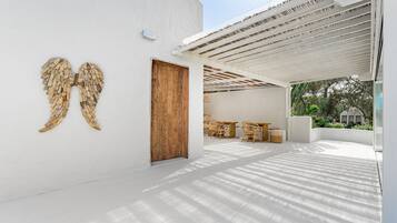 Ein modernes Interieur mit einer Holztür, weißen Wänden und einer Decke mit Holzlatten-Verkleidung.