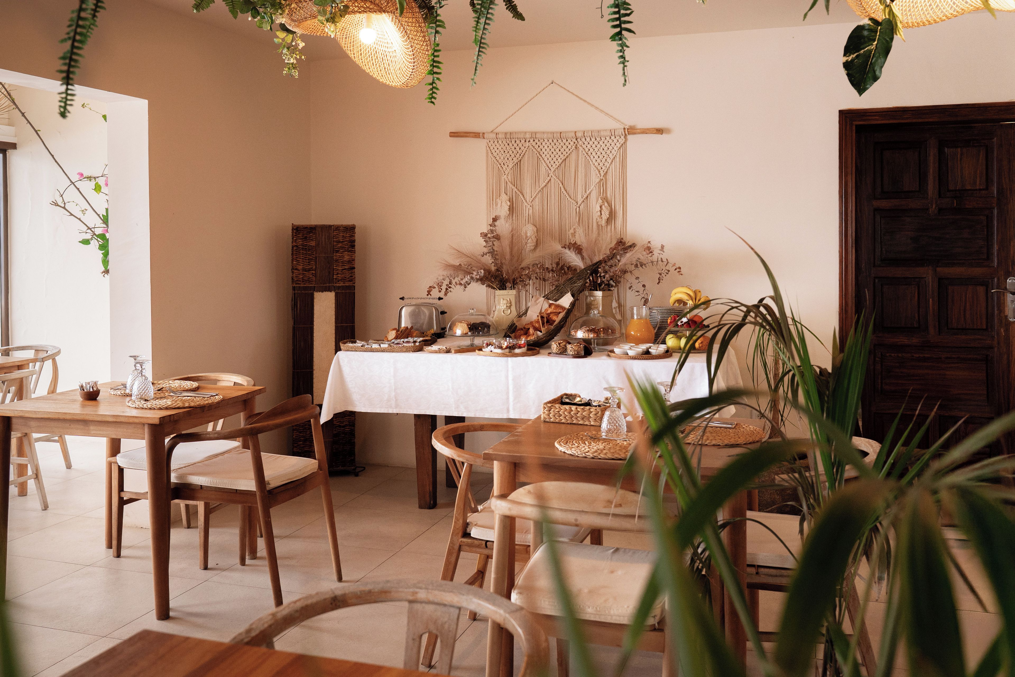 A dining area with a table set for a meal, surrounded by chairs.