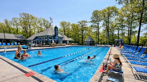 A swimming pool with lanes, lounge chairs, and a covered area with umbrellas. - Pool Access, Pet Friendly w/Pond View & Fire Pit (Hidden Valley)