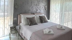 Une chambre moderne avec un grand lit, une table de chevet et une lampe fixée au mur.