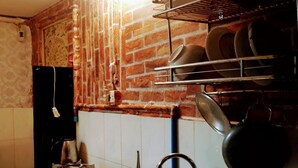 Eine Küche mit Backsteinwand, Spüle, Herd und Kochtopfhalterung.
