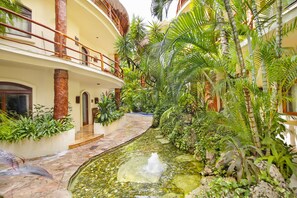 Escape to a serene tropical oasis with a central water feature surrounded by lush greenery and a courtyard.