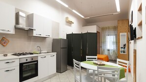Una cocina moderna con armarios blancos, una estufa a gas y un refrigerador. Hay una zona de comedor con una mesa y sillas blancas.