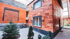 Un edificio moderno con fachada de madera, una bicicleta estacionada afuera y un pequeño árbol de Navidad.