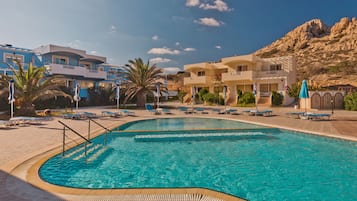 Relax by the pool surrounded by palm trees and mountain views.
