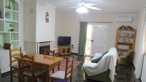 A living room with a dining table, chairs, a sofa, a television, a bookshelf, and a ceiling fan. - Casa Bougainvillea
Relax by the pool, it is yours  for the length of your stay (Lorca)