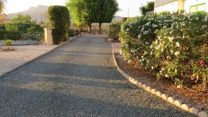 A gravel pathway leading to a building with a green roof, surrounded by well-maintained bushes and trees. - Casa Bougainvillea
Relax by the pool, it is yours  for the length of your stay (Lorca)