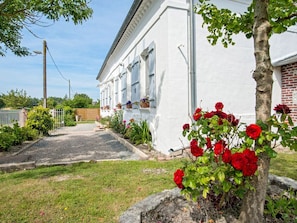 Classic building with a symmetrical facade, surrounded by a well-maintained garden and a brick wall.