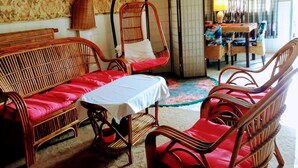 Une pièce comprenant un lit, une table et deux chaises en osier.