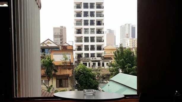 Un balcon donnant sur un immeuble de grande hauteur et les bâtiments environnants.