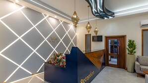 Et receptionsområde med en mørkeblå disk, et geometrisk design af lys på væggen og en reception med teksten "Reception".