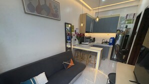 A modern kitchen with grey cabinets, a white countertop, and a built-in microwave. - The Most Romantic Staycation in the City (Tacloban City)