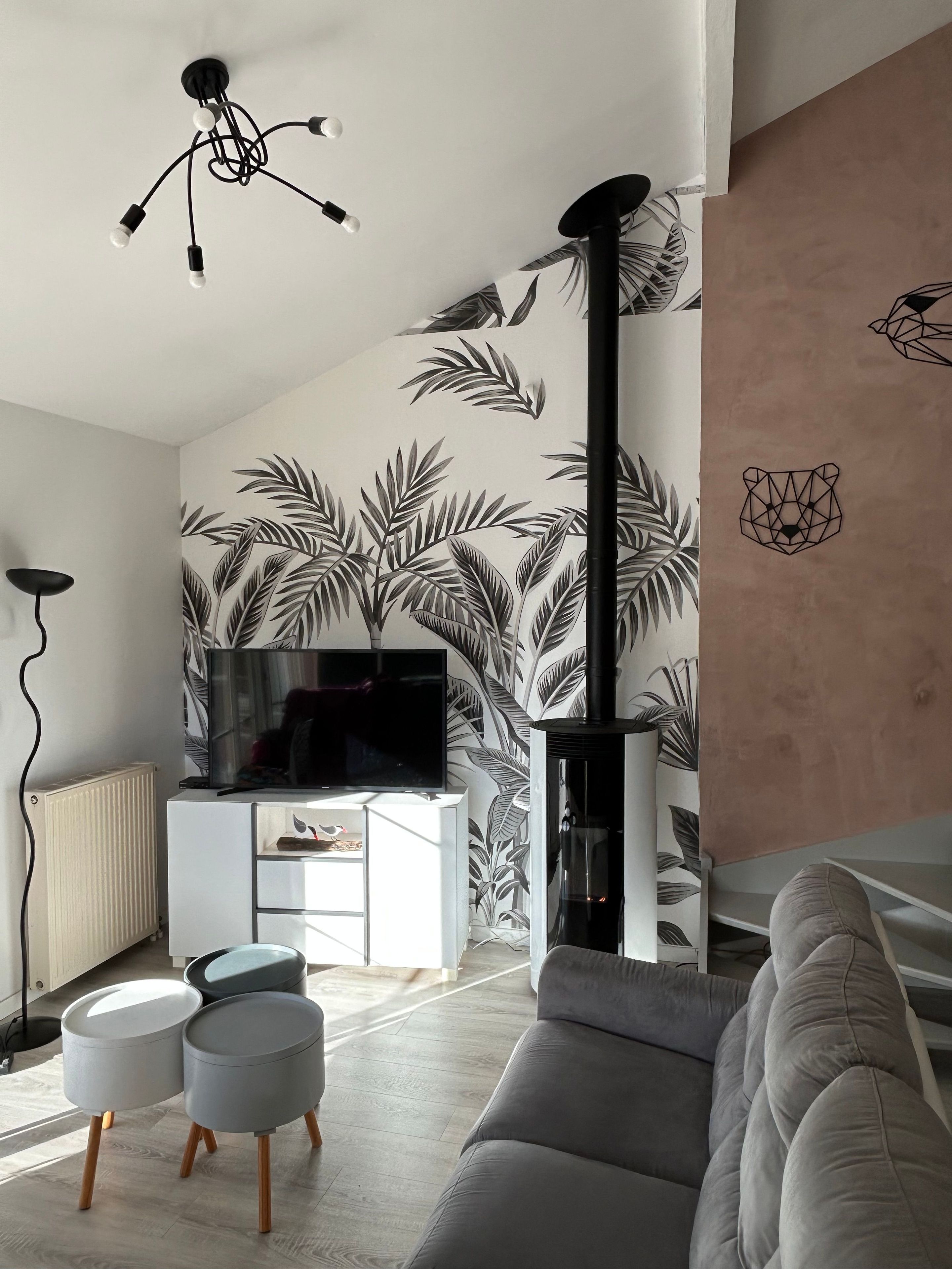 A modern living room with a flat-screen TV, a fireplace, and a sofa.