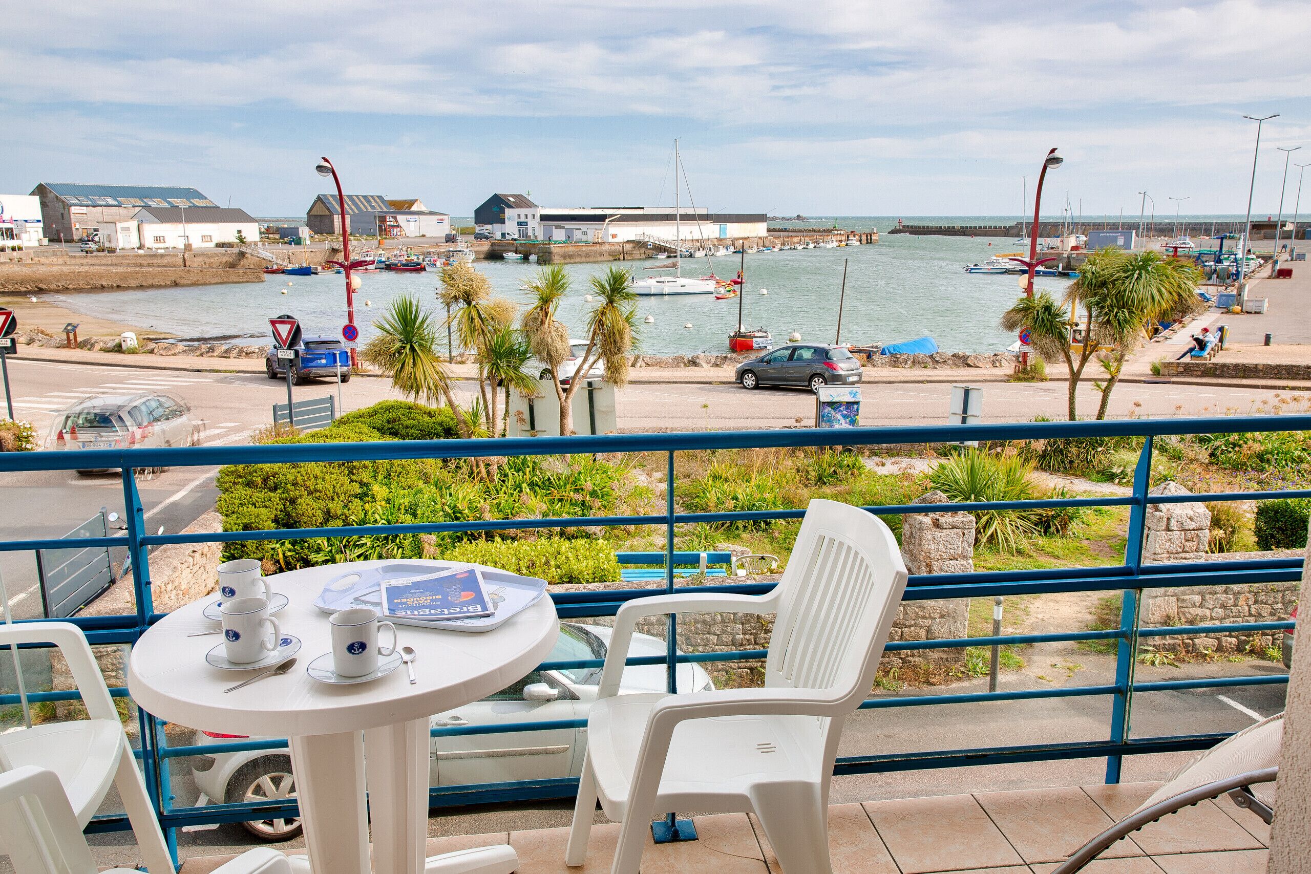 Un balcon avec vue sur une marina, comprenant des bateaux et une jetée.