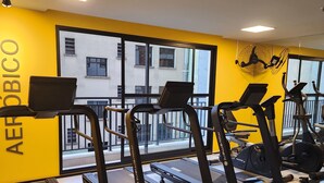 Une salle de sport équipée de tapis de course, d’un vélo d’appartement et d’un appareil d’aviron.