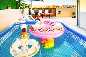 Relax by the pool surrounded by lush greenery and comfortable seating.