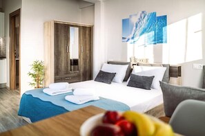 Relax in a serene space with a neatly made bed, wooden wardrobe, and large window.