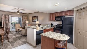 Eine moderne Küche mit Granit Arbeitsplatten, einem schwarzen Kühlschrank und Holzschränken.