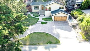 A two-story house with a garage, a driveway, and a well-maintained lawn.