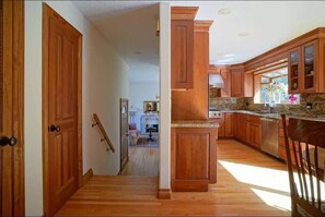 A kitchen with wooden cabinets, granite countertops, and a built-in dishwasher.
