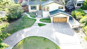 Une maison moderne à deux étages, dotée d’un garage, d’une allée et d’une pelouse bien entretenue.