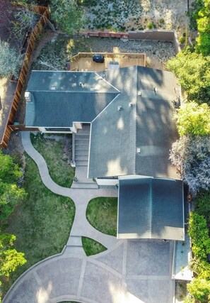 A modern two-story house with a sloped roof, a covered patio, and a landscaped yard with a winding pathway. - New! Coastal Serene Home in the Heart of Monterey! (Monterey)